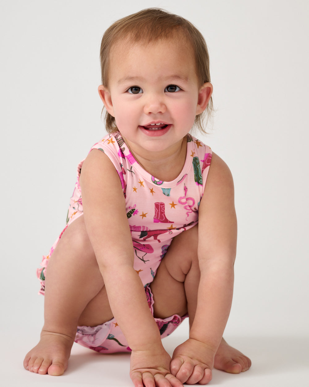 Sitting child wearing the Pink Rancher Roundup Bubble Romper