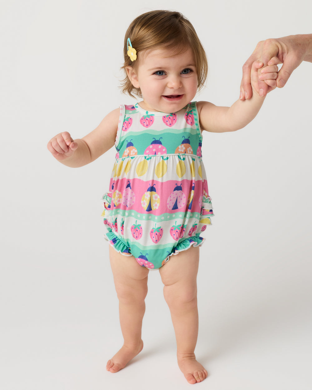 Standing baby wearing the Ladybug Lane Bubble Romper