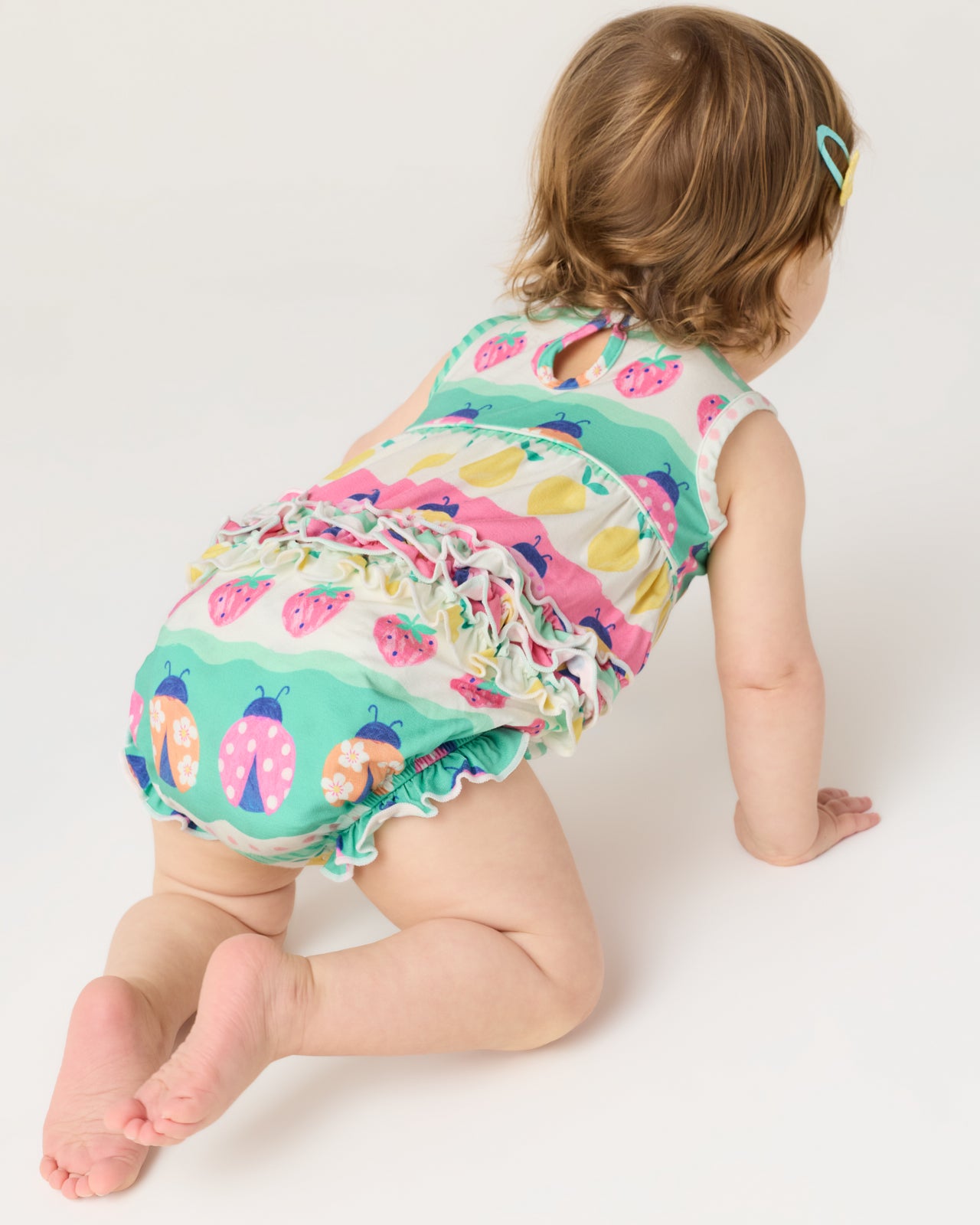 Back view of crawling baby wearing the Ladybug Lane Bubble Romper
