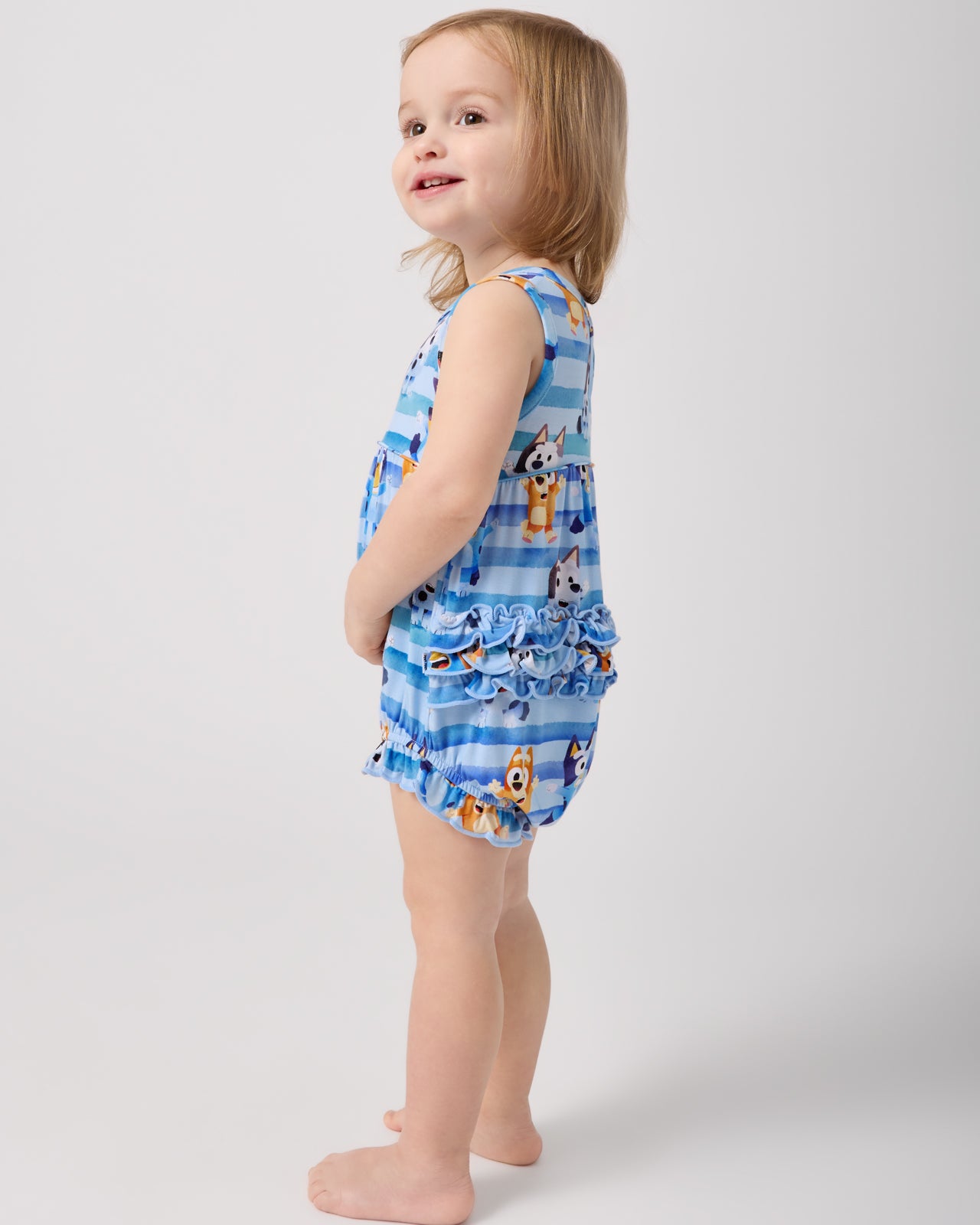 Side view of standing toddler wearing the Bluey Dance All Day Bubble Romper