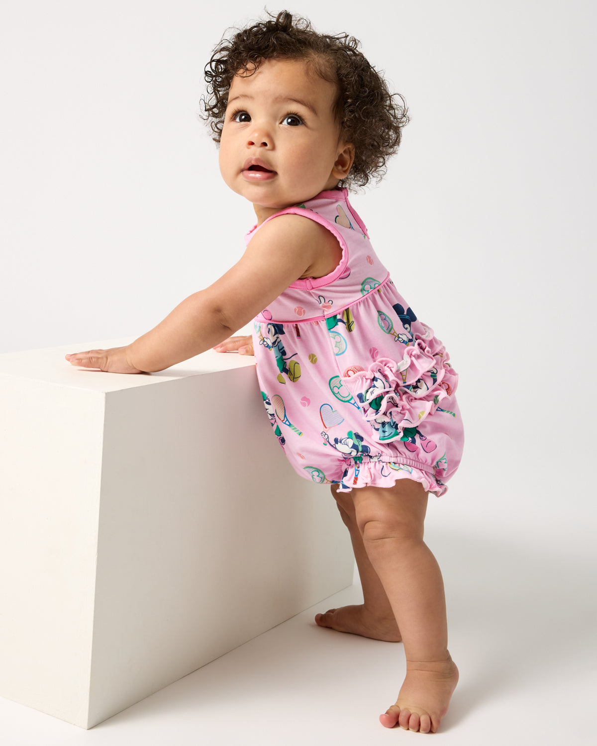 Standing baby wearing the Disney Mickey Mouse & Minnie Mouse Match Bubble Romper