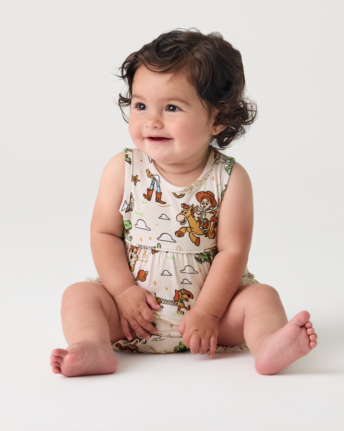 Sitting baby wearing the Disney & Pixar Woody's Wild West Bubble Romper