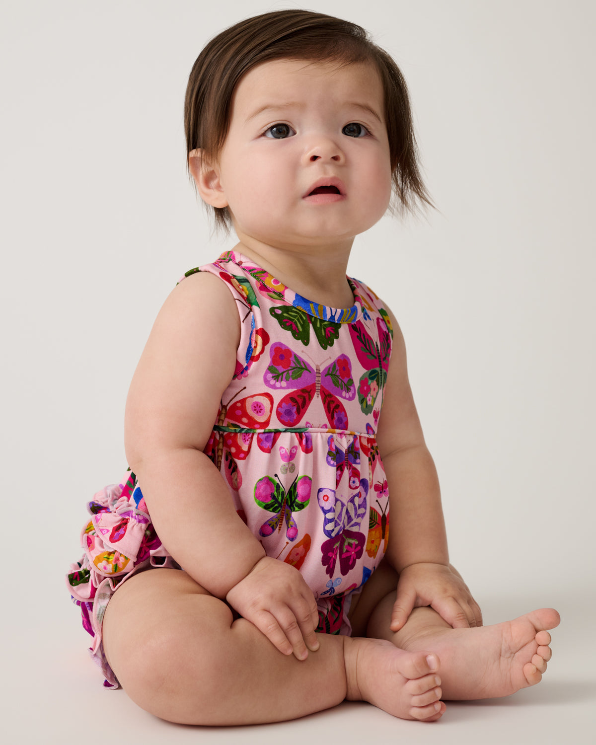 Sitting baby wearing the Flutter Garden Bubble Romper