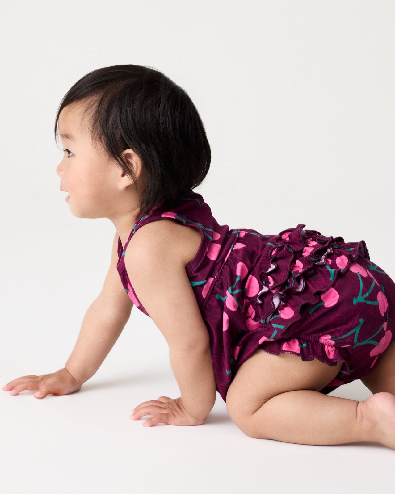 Crawling baby wearing the Cherry Charm Bubble Romper