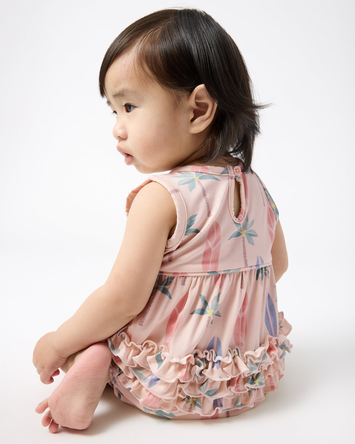 Back view of sitting baby wearing the Palm Dunes Bubble Romper