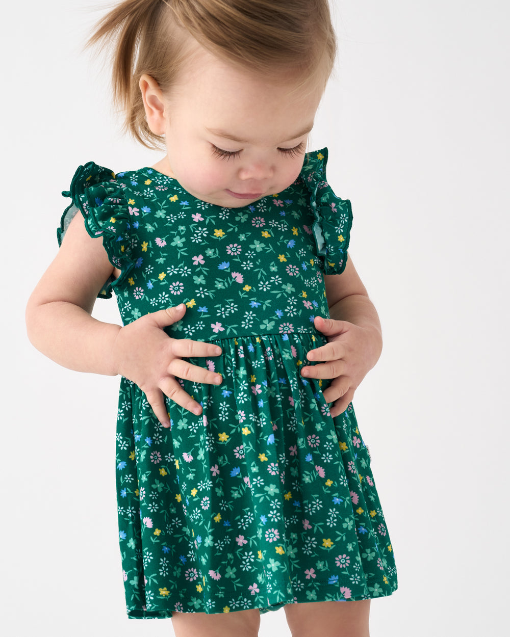 Close up of baby wearing the Emerald Meadow Flutter Twirl Dress with Bodysuit