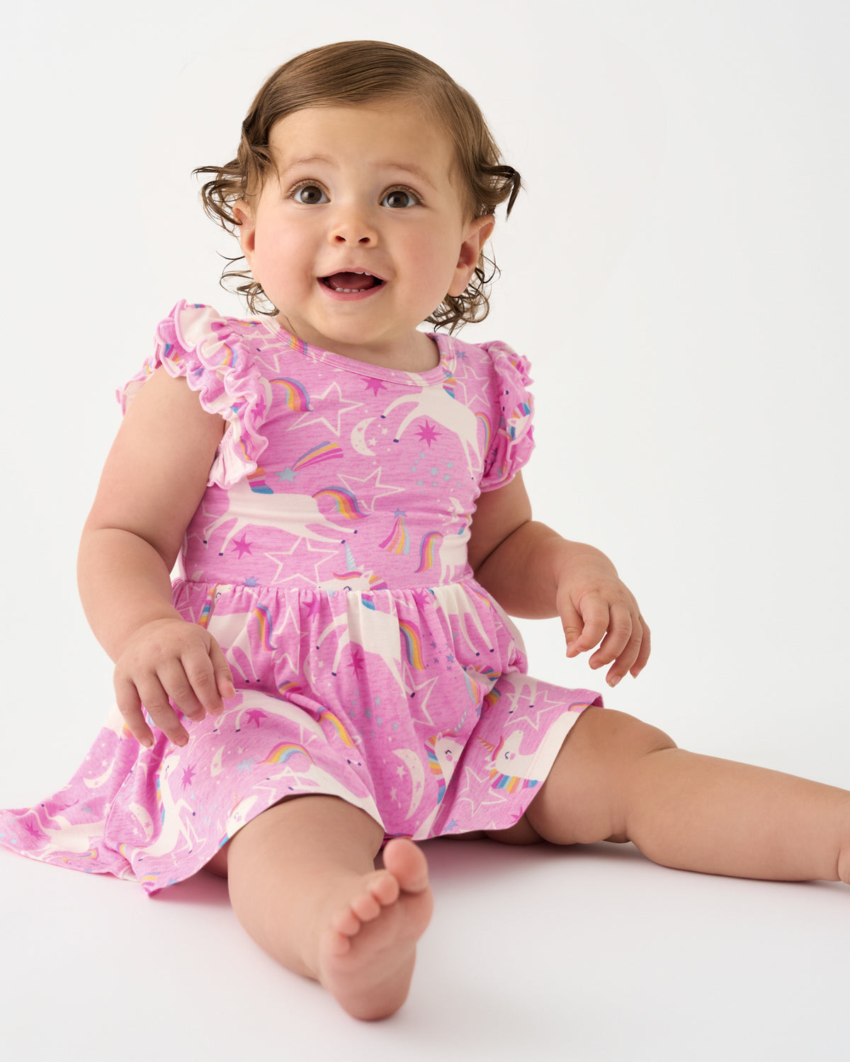 Sitting baby wearing the Unicorn Dance Flutter Twirl Dress with Bodysuit