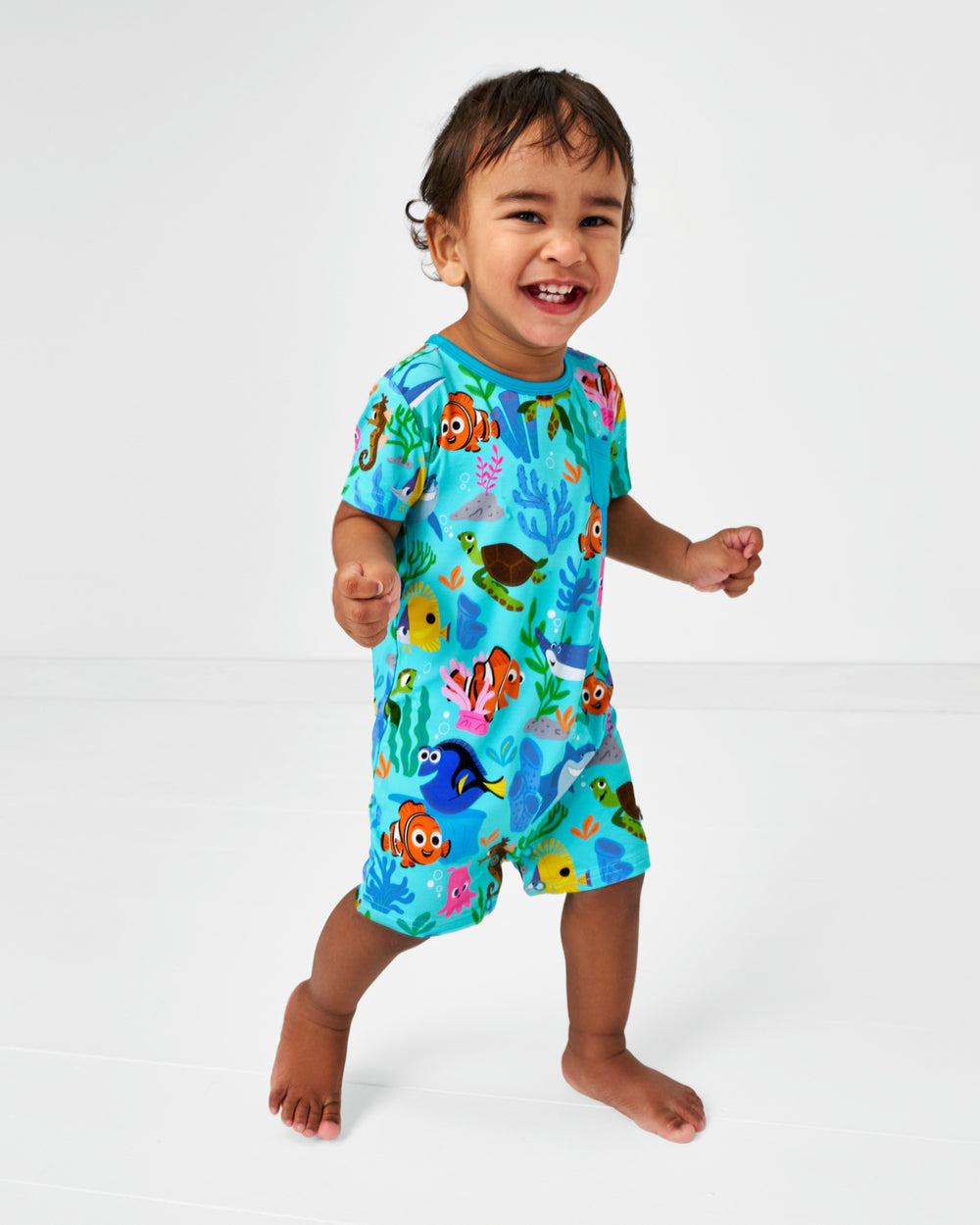 Walking child wearing the Disney Nemo's Reef Pocket Shorty Romper
