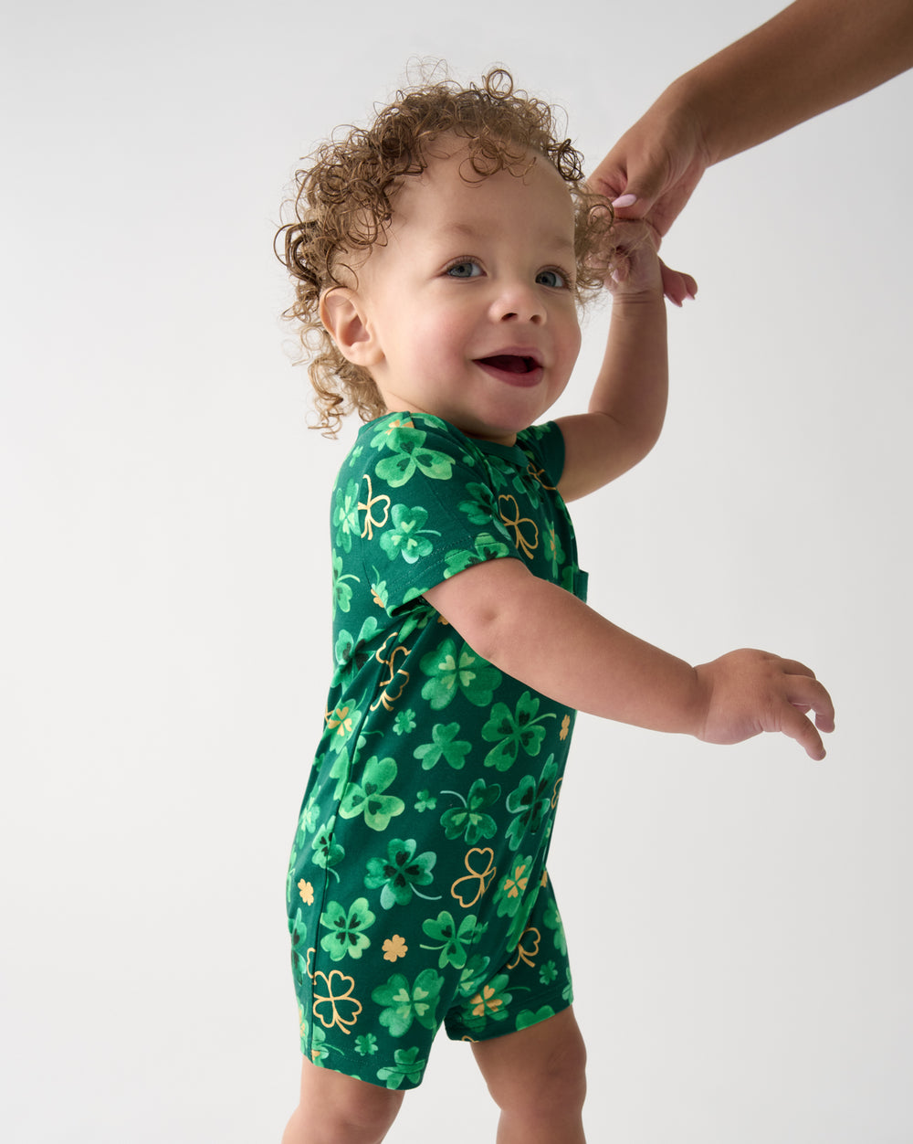 Walking toddler wearing the Clover Cuties Pocket Shorty Romper