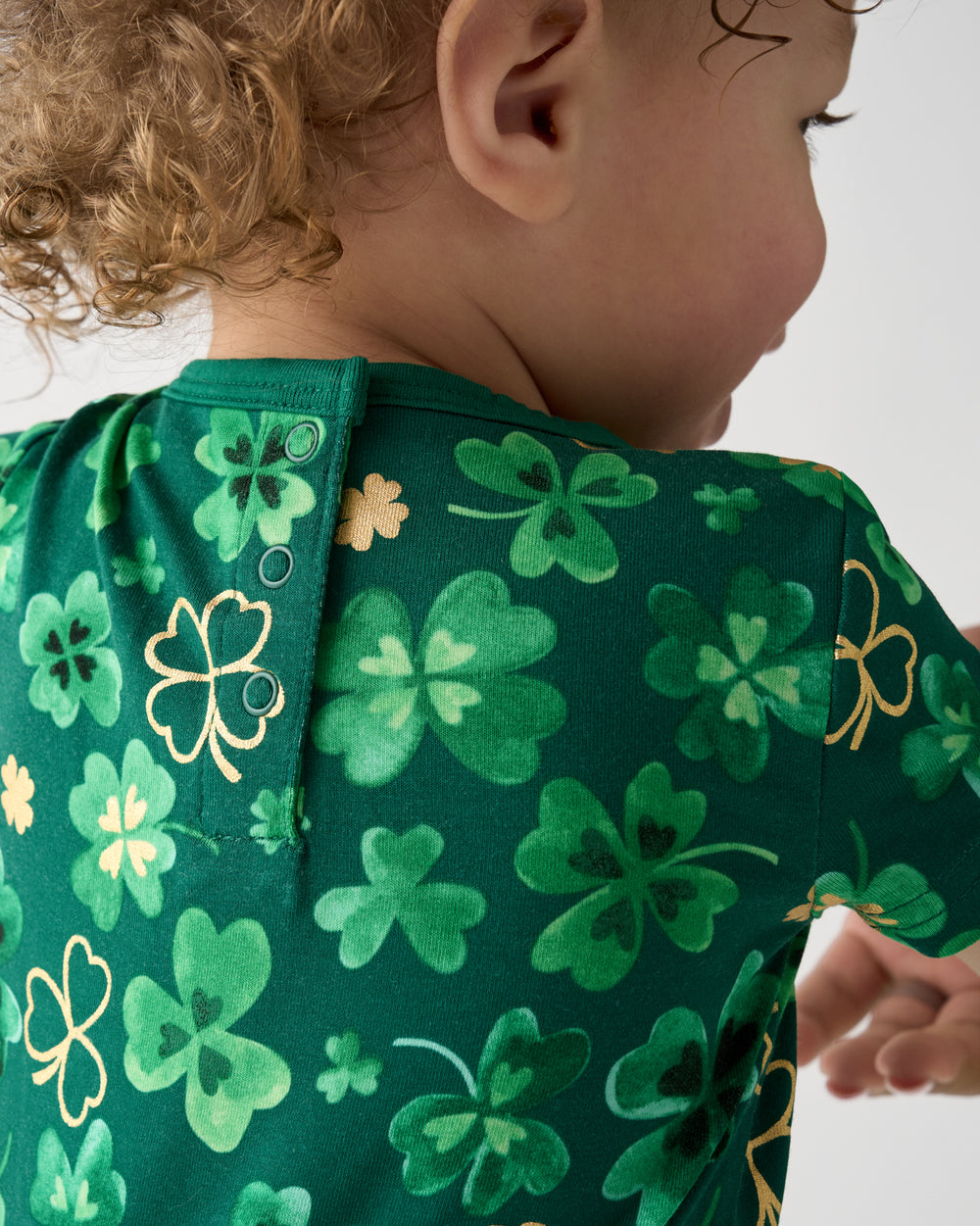 Close up of the snap buttons on the back on the Clover Cuties Pocket Shorty Romper