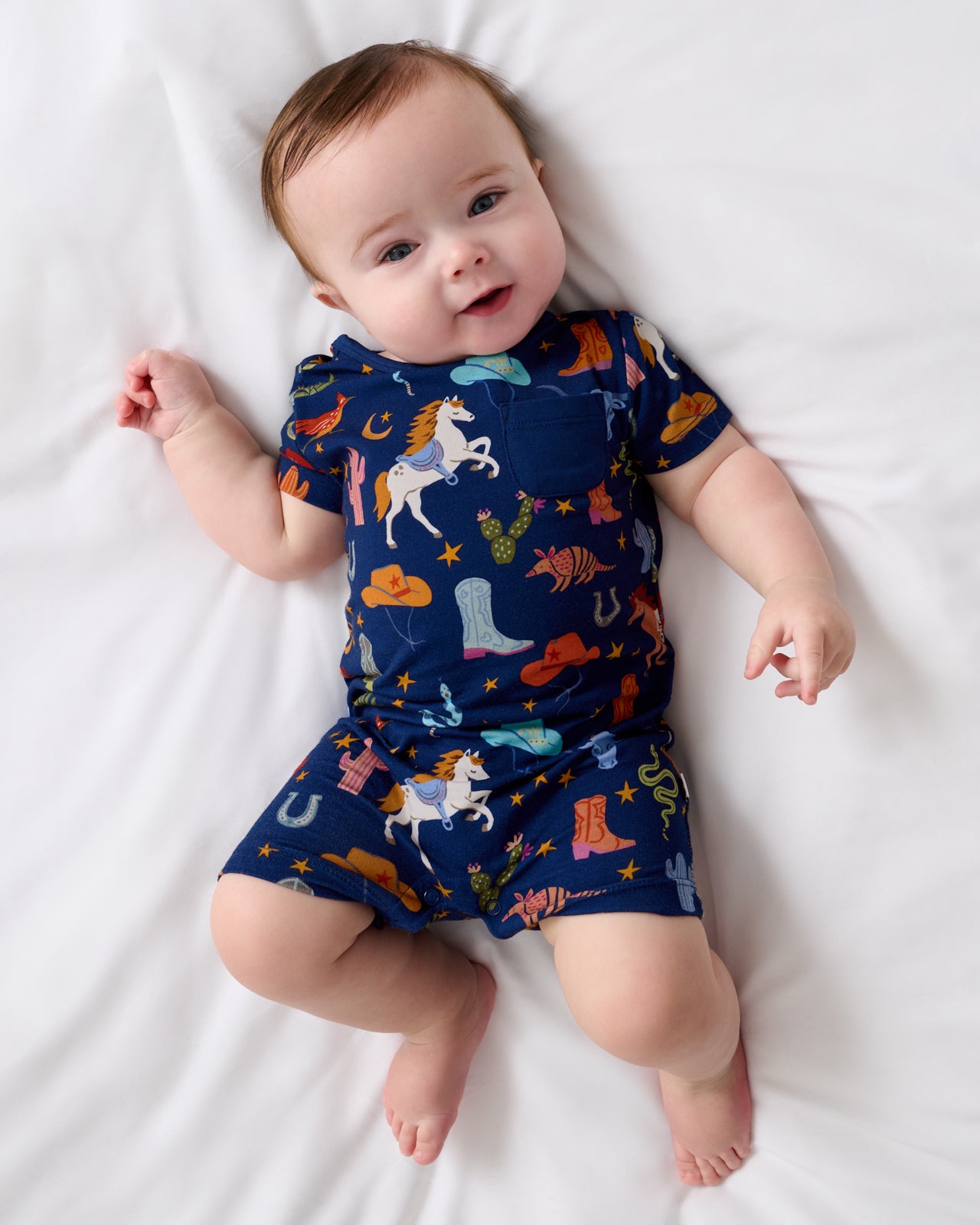 Aerial view of baby wearing the Blue Rancher Roundup Pocket Shorty Romper