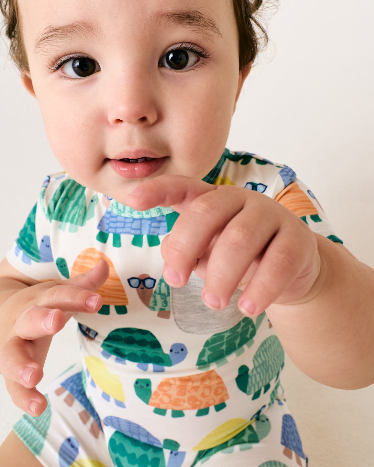 Close up of baby boy wearing the Shell Parade Pocket Shorty Romper