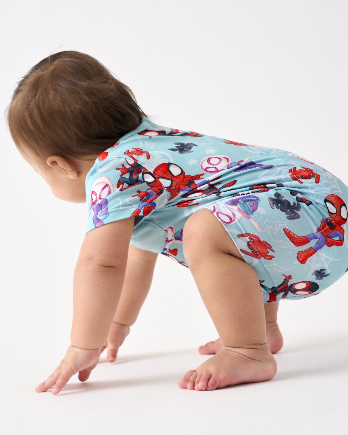 Crawling baby wearing the Spidey & Friends Tiny Webs Pocket Shorty Romper