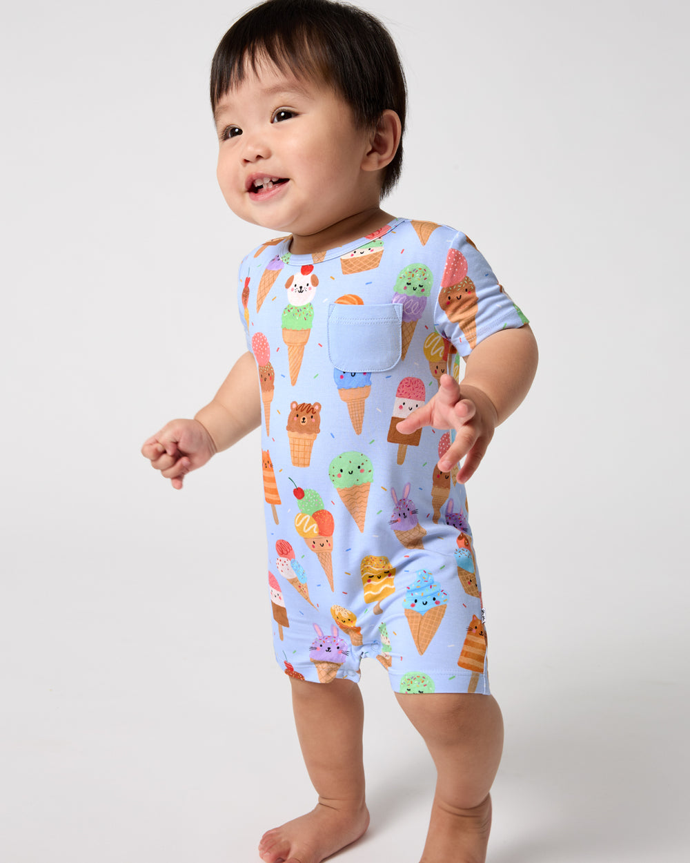 Standing toddler wearing the Scoop Squad Pocket Shorty Romper