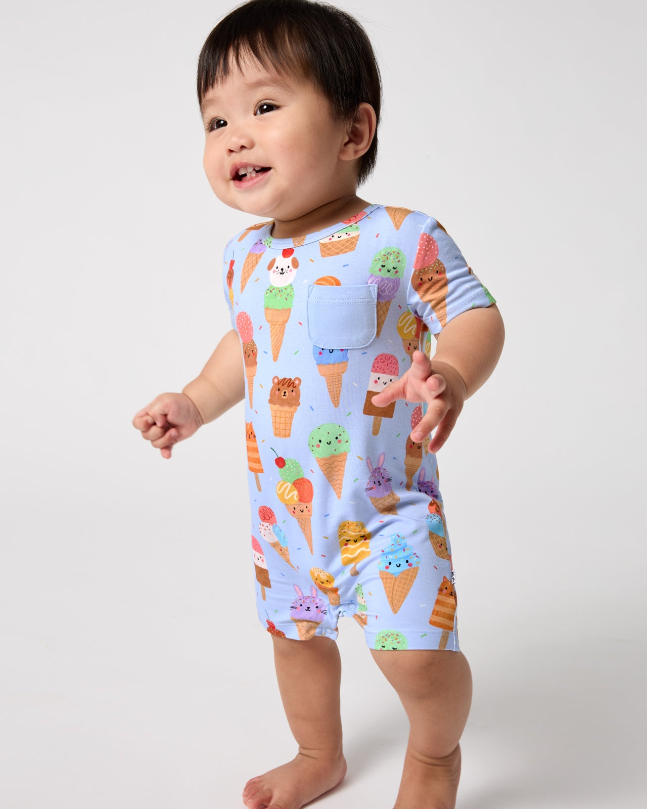 Standing toddler wearing the Scoop Squad Pocket Shorty Romper
