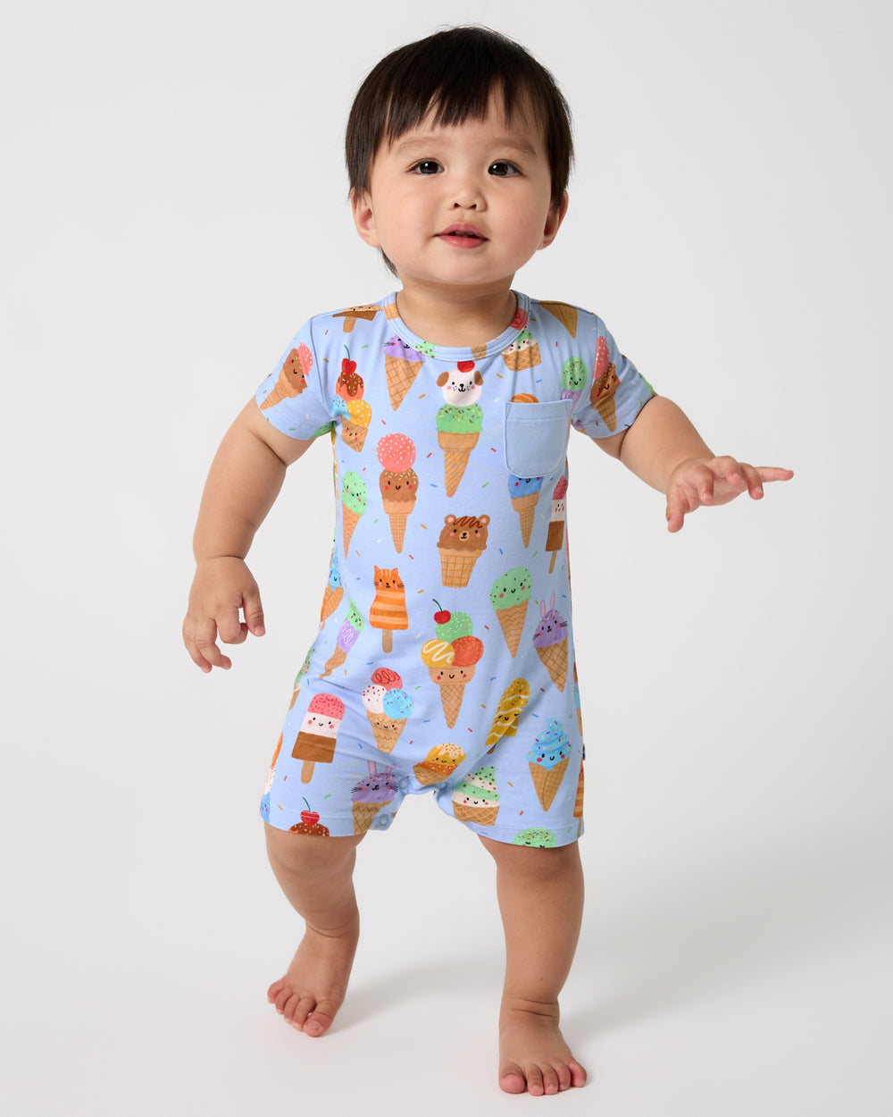 Walking baby wearing the Scoop Squad Pocket Shorty Romper
