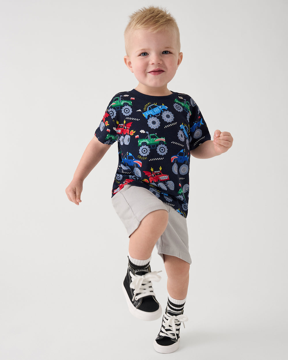 Child in motion wearing the Monster Truck Madness Relaxed Tee with gray chino shorts