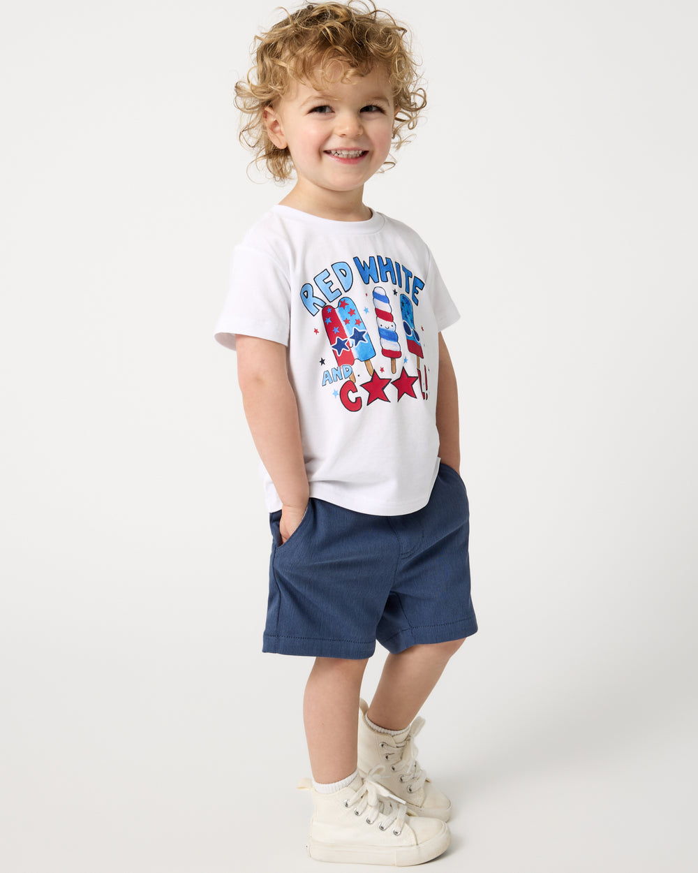 Boy wearing the Red White & Cool Relaxed Tee with navy shorts