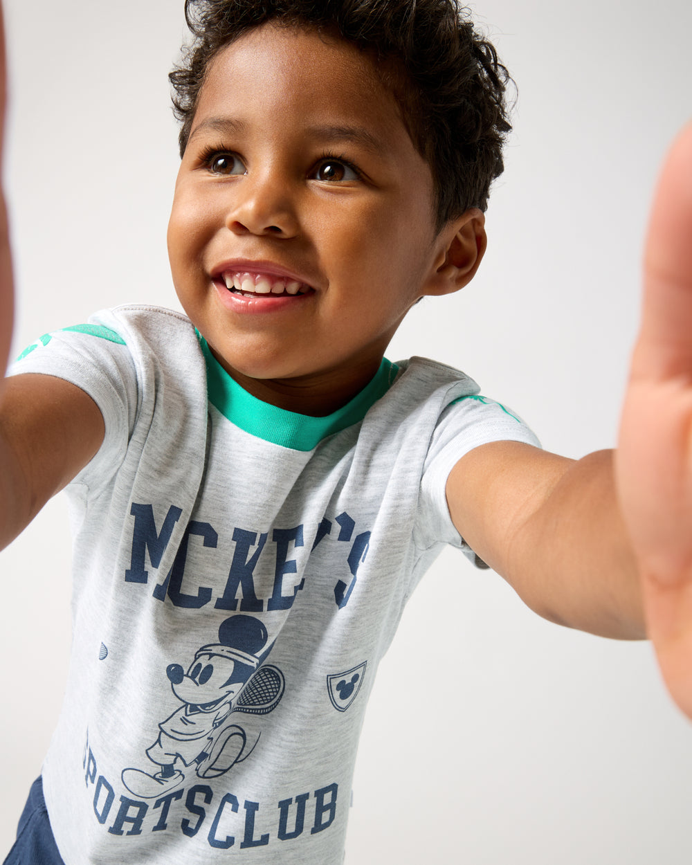 Boy wearing the Disney Mickey Mouse Sports Club Relaxed Tee holding the camera