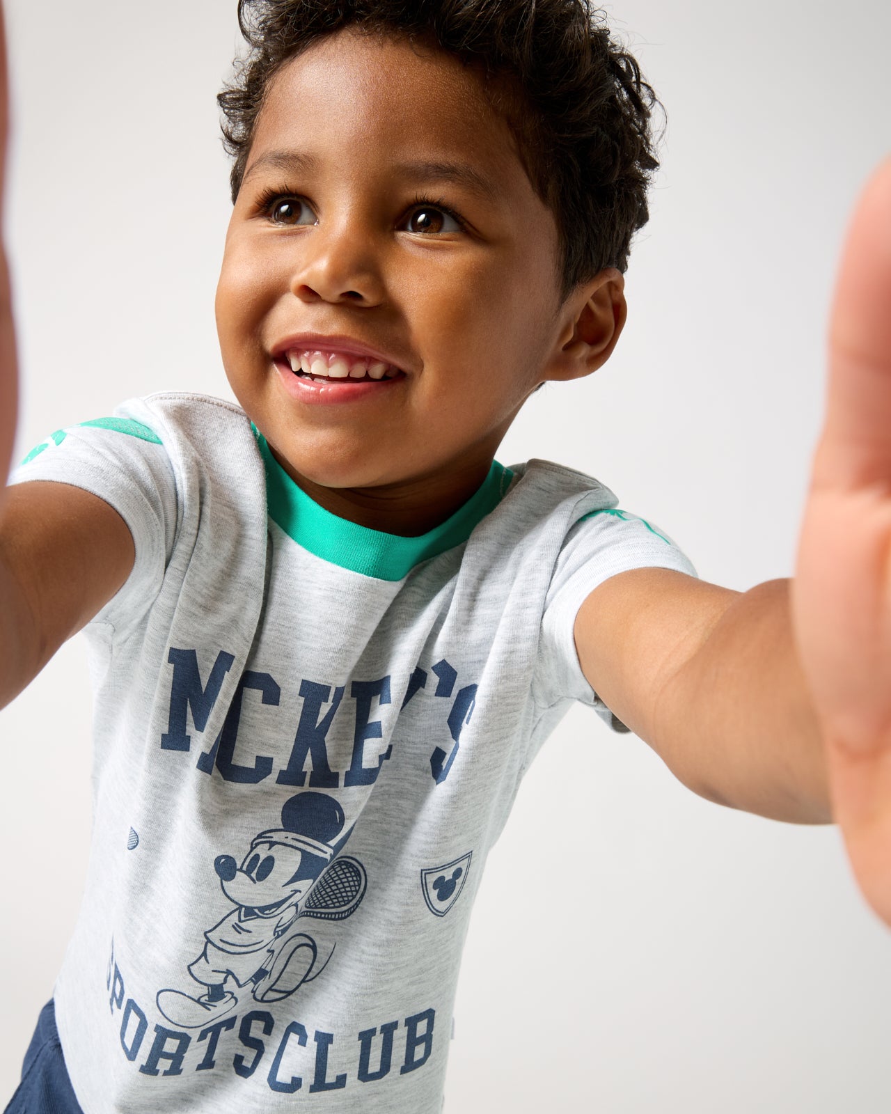 Boy wearing the Disney Mickey Mouse Sports Club Relaxed Tee holding the camera