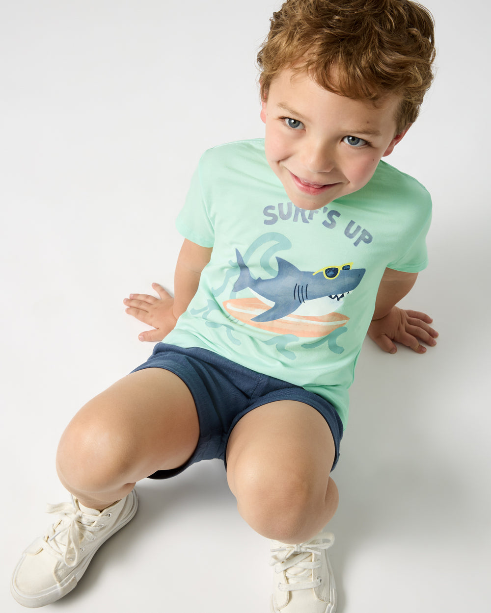 Aerial view of boy wearing the Surf's Up Relaxed Tee with navy shorts