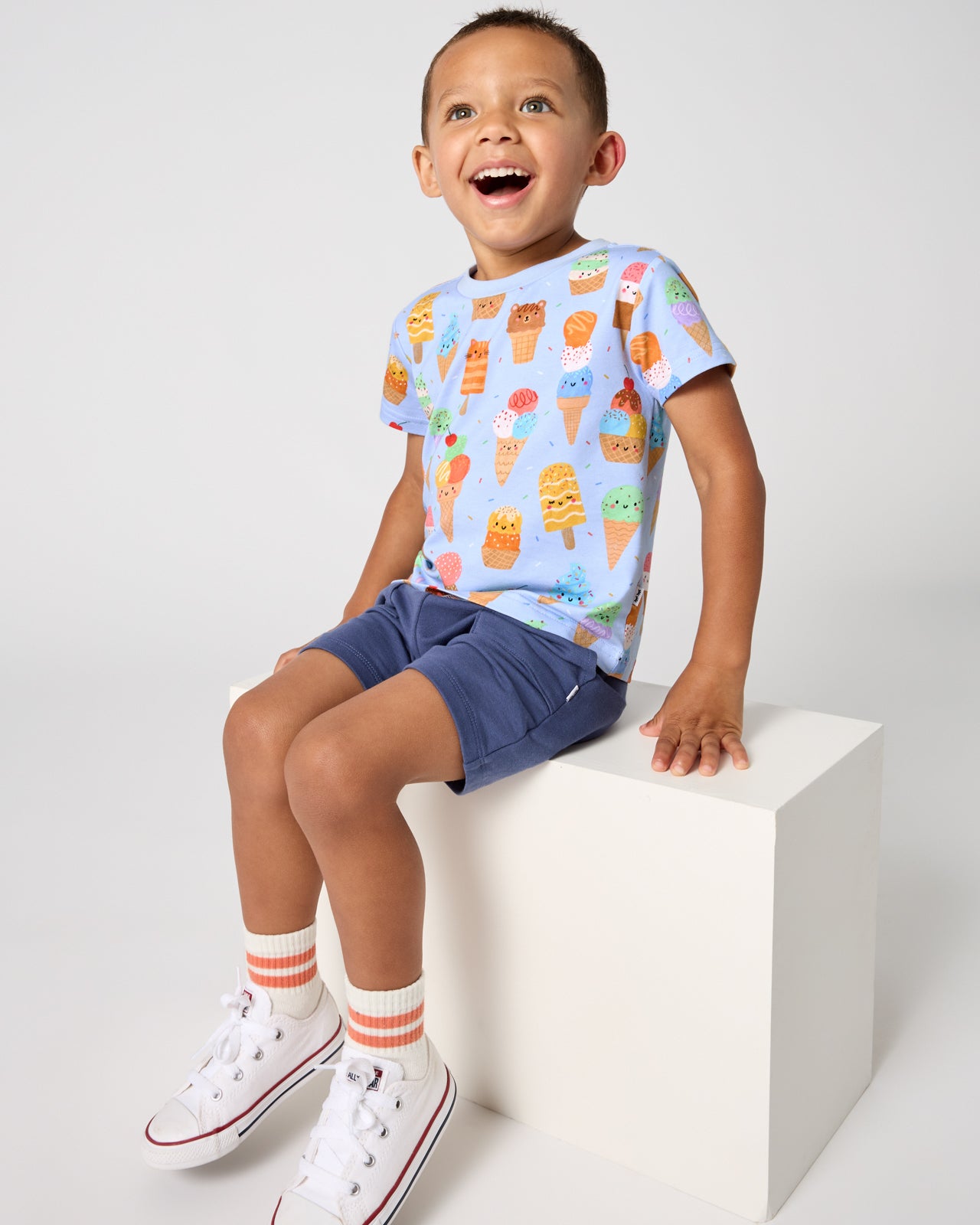 Boy wearing the Scoop Squad Relaxed Tee with navy blue shorts
