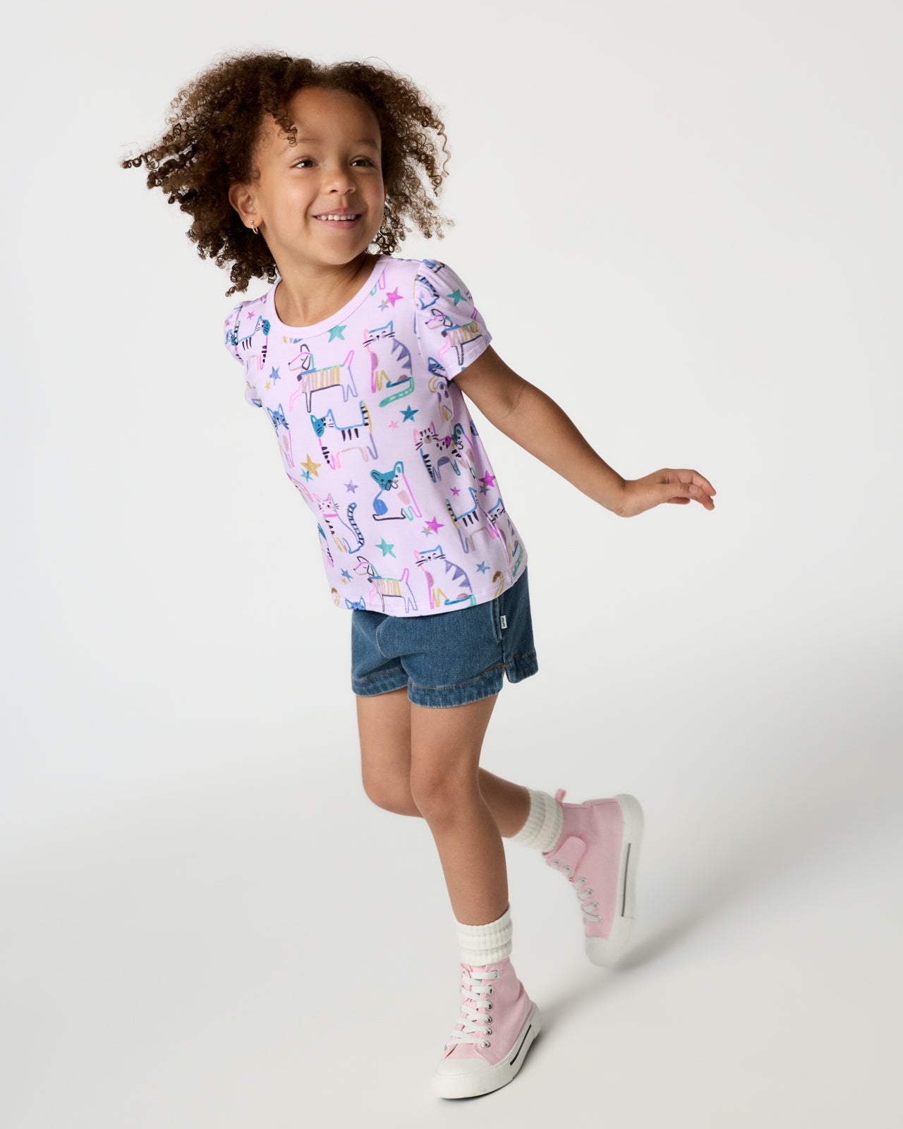 Girl wearing the Whiskers & Wags Purple Puff Sleeve Tee with denim shorts