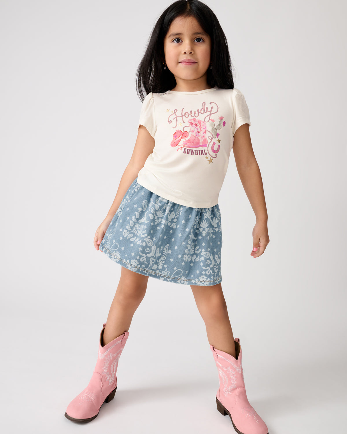 Standing girl wearing the Bandana Blues Denim Skort with a graphic tee