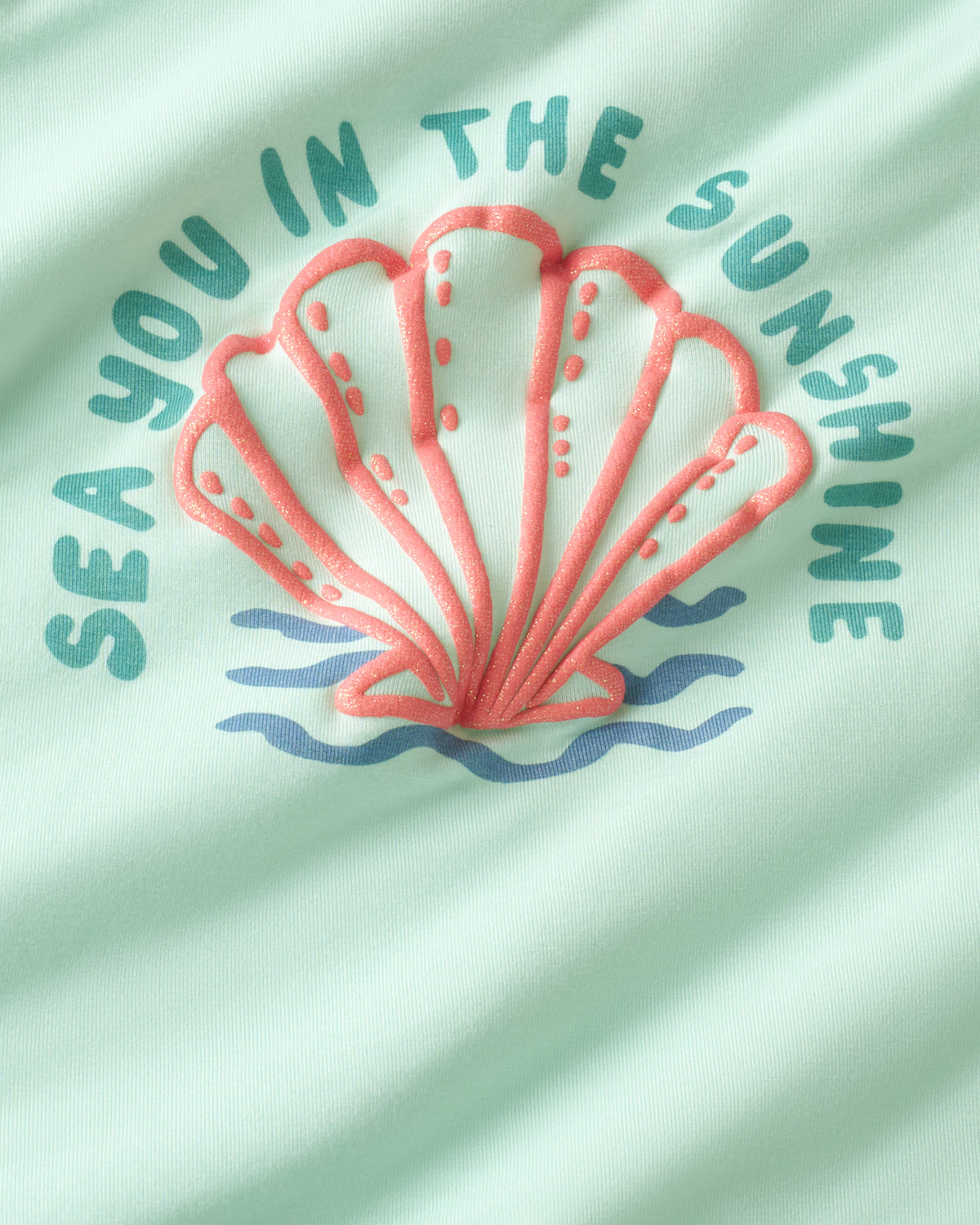 Close up of the graphic on the Sparkling Seas Puff Sleeve Tee