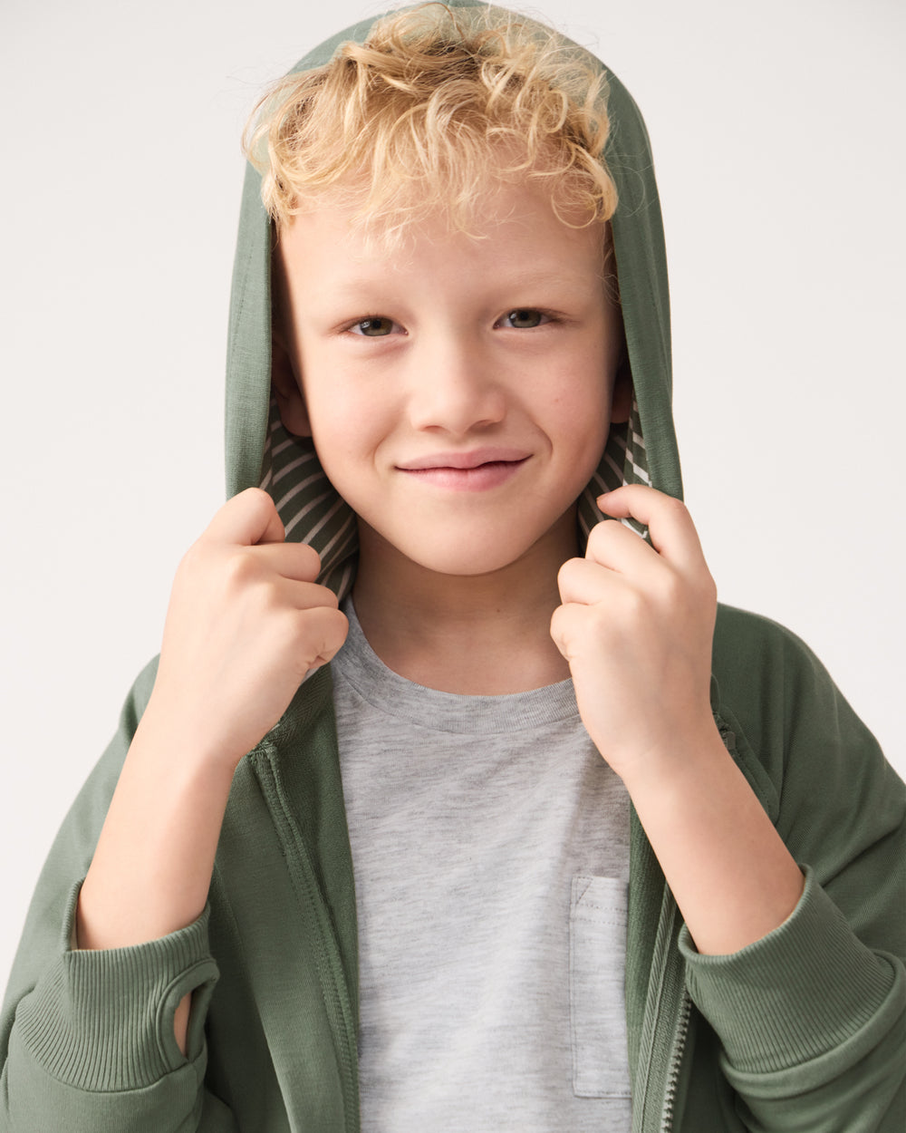 Boy wearing the Moss Zip Hoodie with the hood on