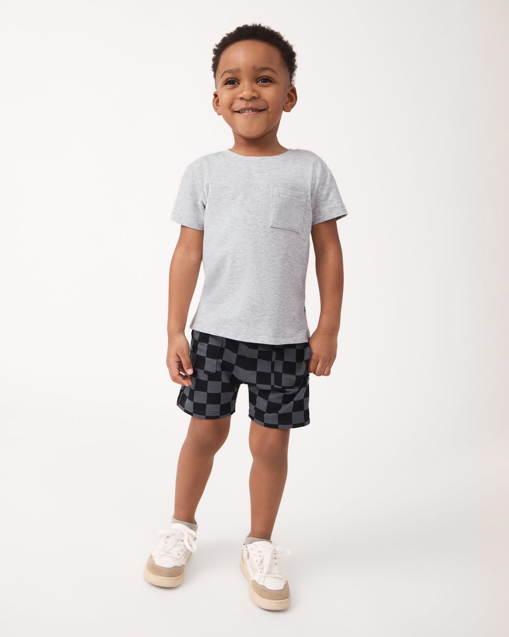 Boy wearing the Light Heather Gray Relaxed Pocket Tee with checker print boys shorts