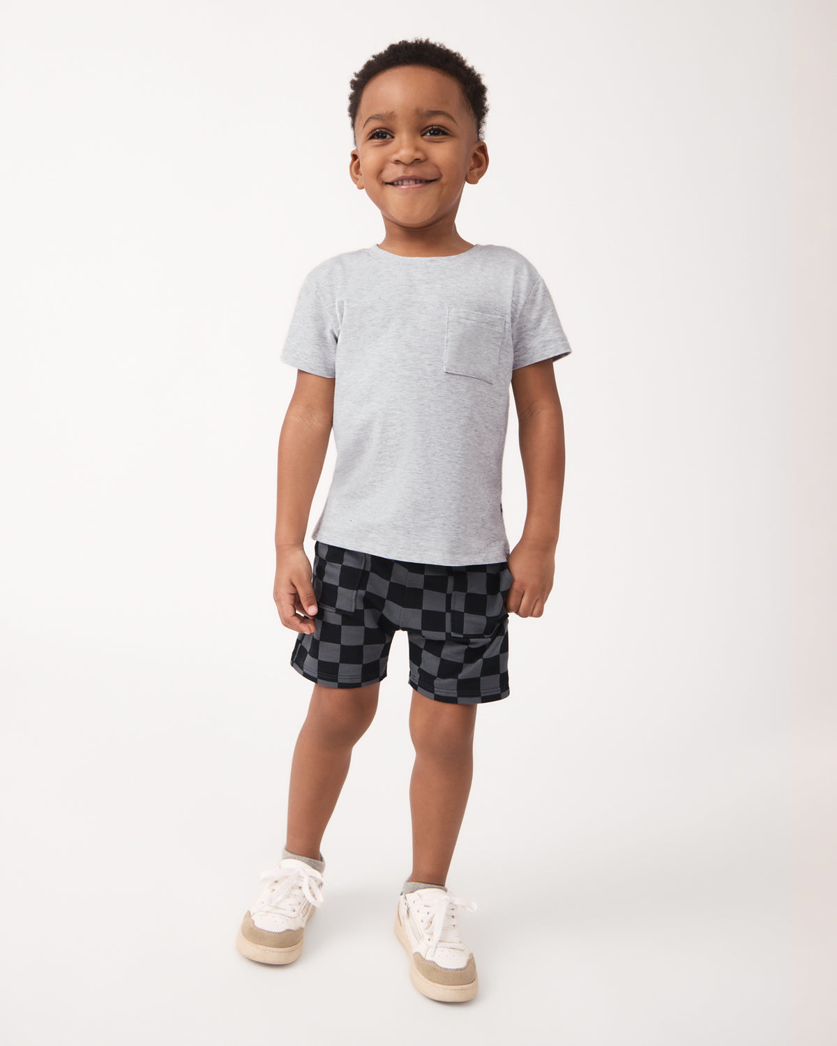 Boy wearing the Light Heather Gray Relaxed Pocket Tee with checker print boys shorts