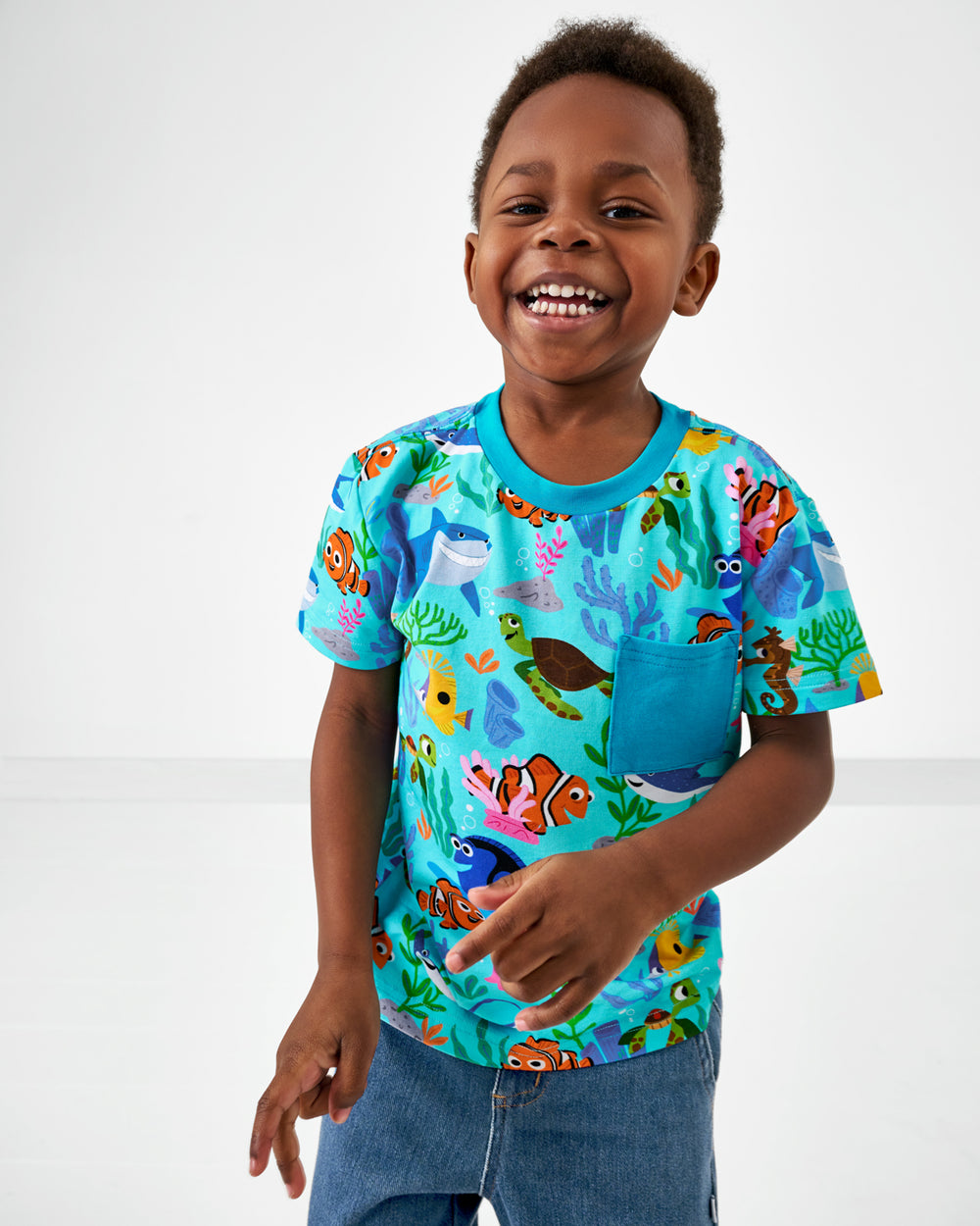 Smiling child wearing the Disney Nemo's Reef Relaxed Pocket Tee