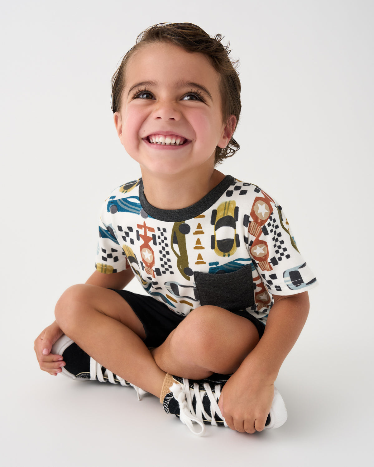 Sitting boy wearing the Fast Lane Relaxed Pocket Tee