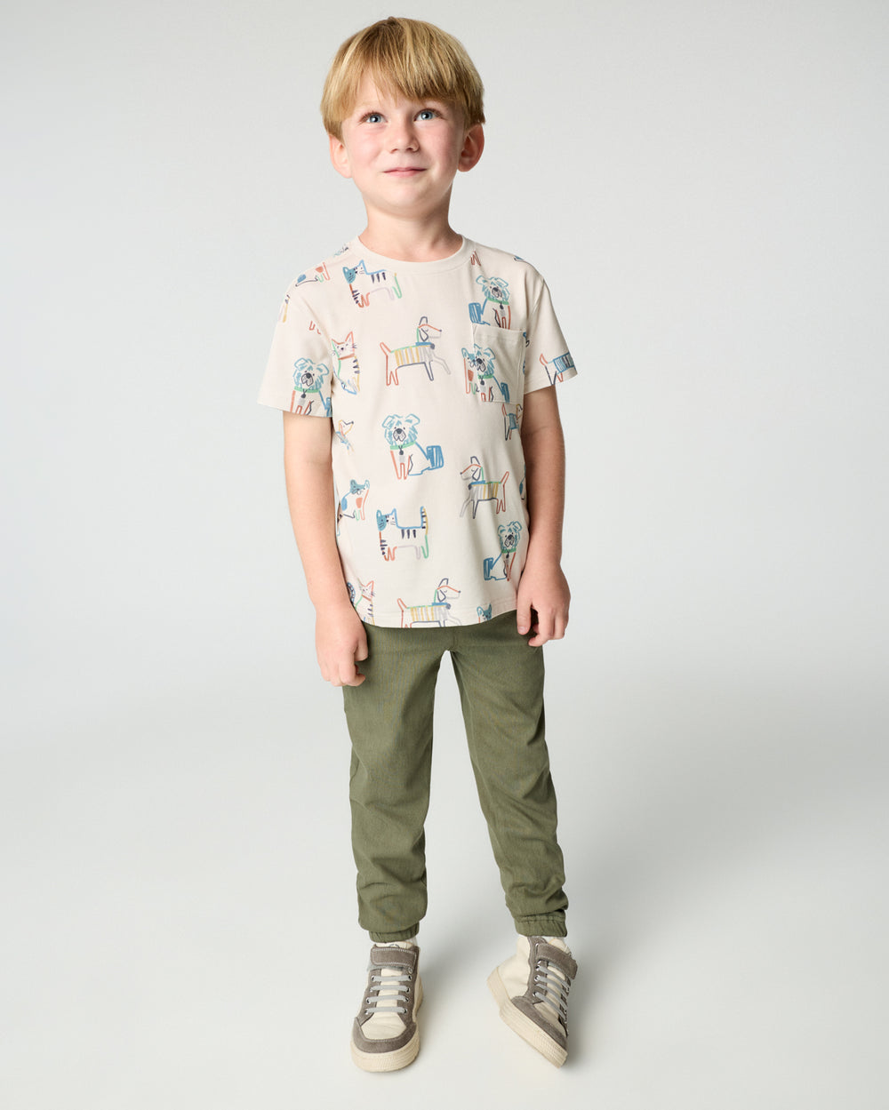 Boy wearing the Whiskers & Wags Relaxed Pocket Tee with green joggers
