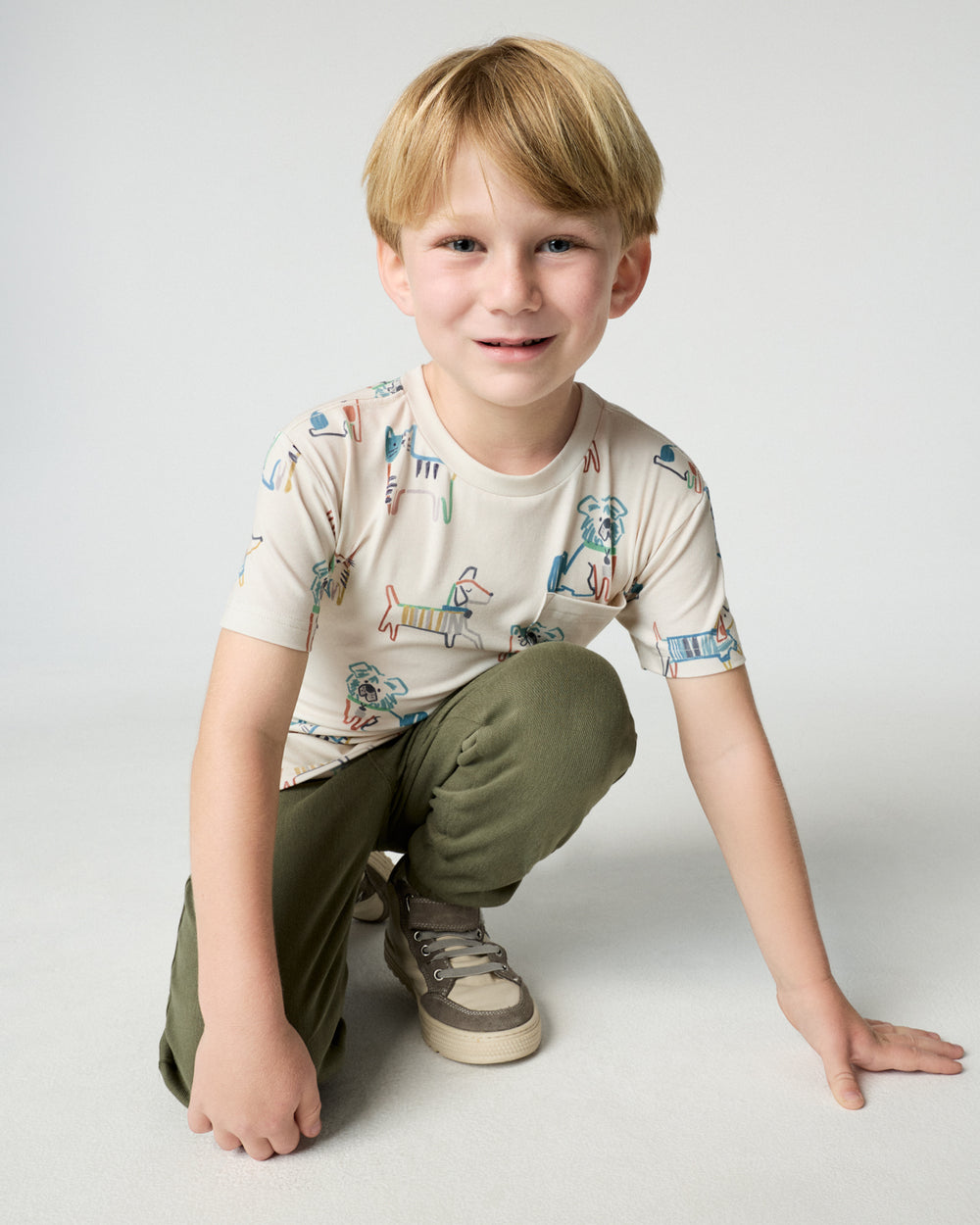 Kneeling child wearing the Whiskers & Wags Relaxed Pocket Tee