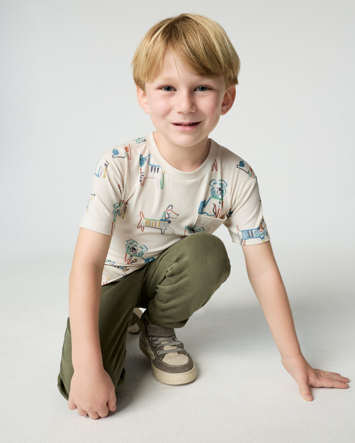 Kneeling child wearing the Whiskers & Wags Relaxed Pocket Tee