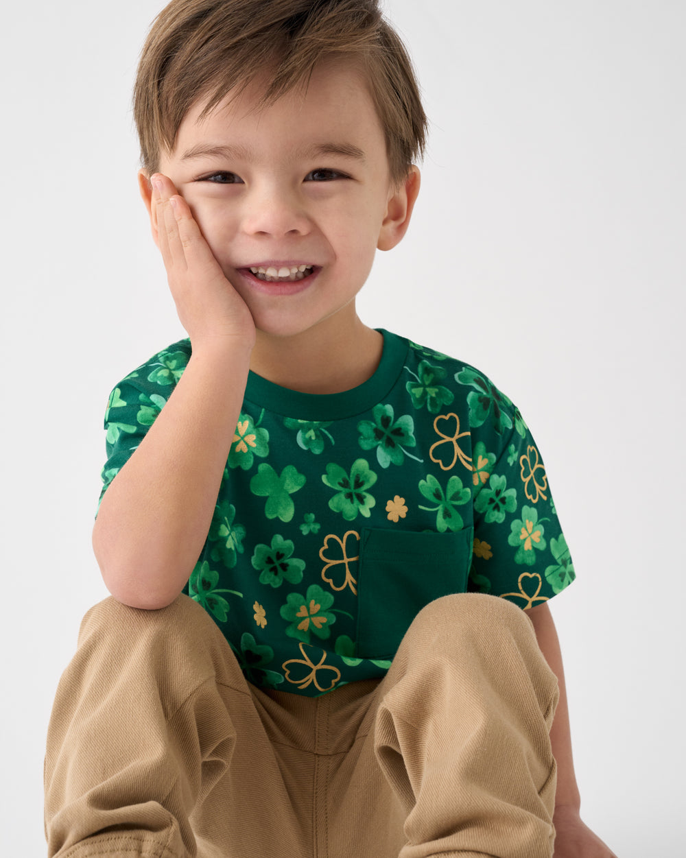 Sitting boy wearing the Clover Cuties Relaxed Pocket Tee with khaki pants