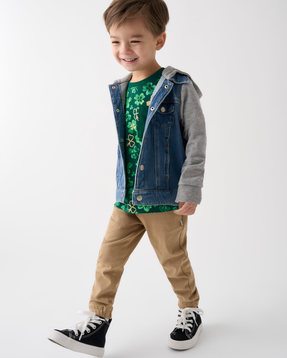 Walking boy wearing the Clover Cuties Relaxed Pocket Tee layered under a denim trucker jacket