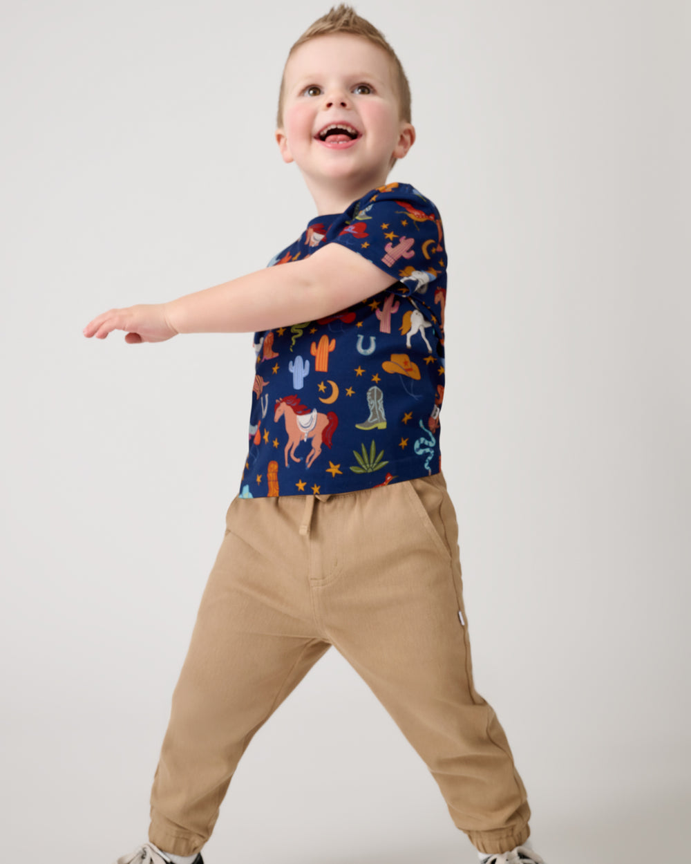 Child in motion wearing the Blue Rancher Roundup Relaxed Pocket Tee with denim joggers