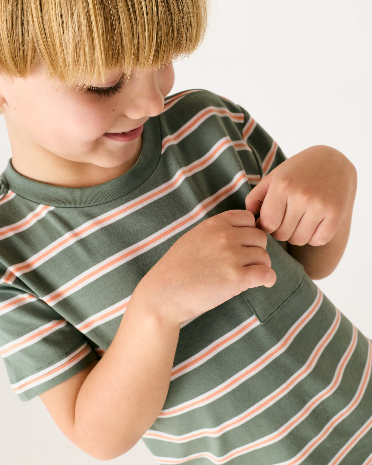 Child looking in the pocket of the Moss Stripe Relaxed Pocket Tee