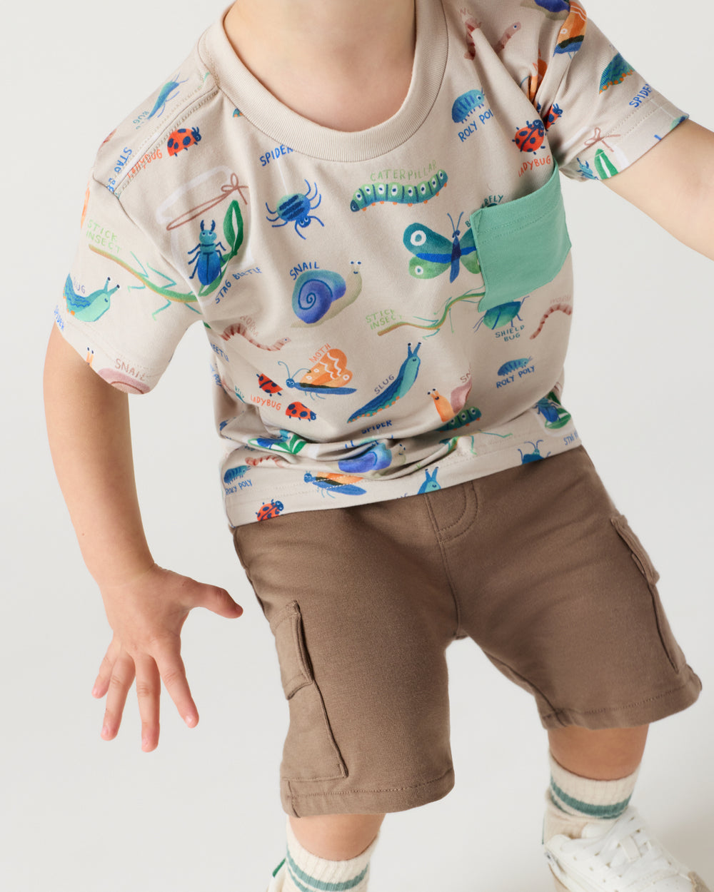 Close up of child wearing the Nature Notes Relaxed Pocket Tee with brown boys shorts