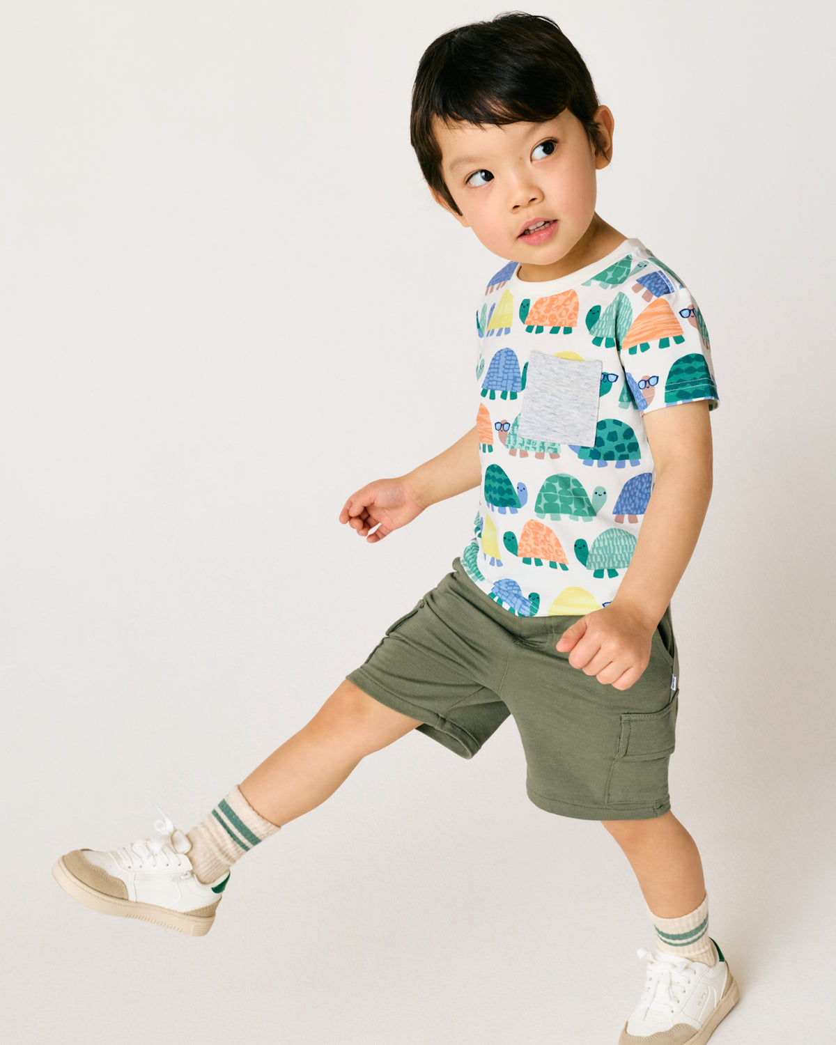 Child wearing the Shell Parade Relaxed Pocket Tee with green boys cargo shorts