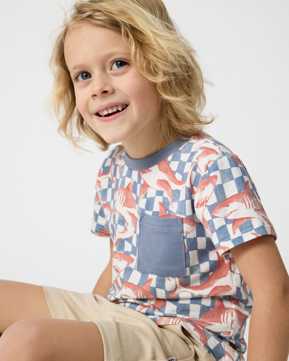 Sitting boy wearing the Shark Fin Checks Relaxed Pocket Tee