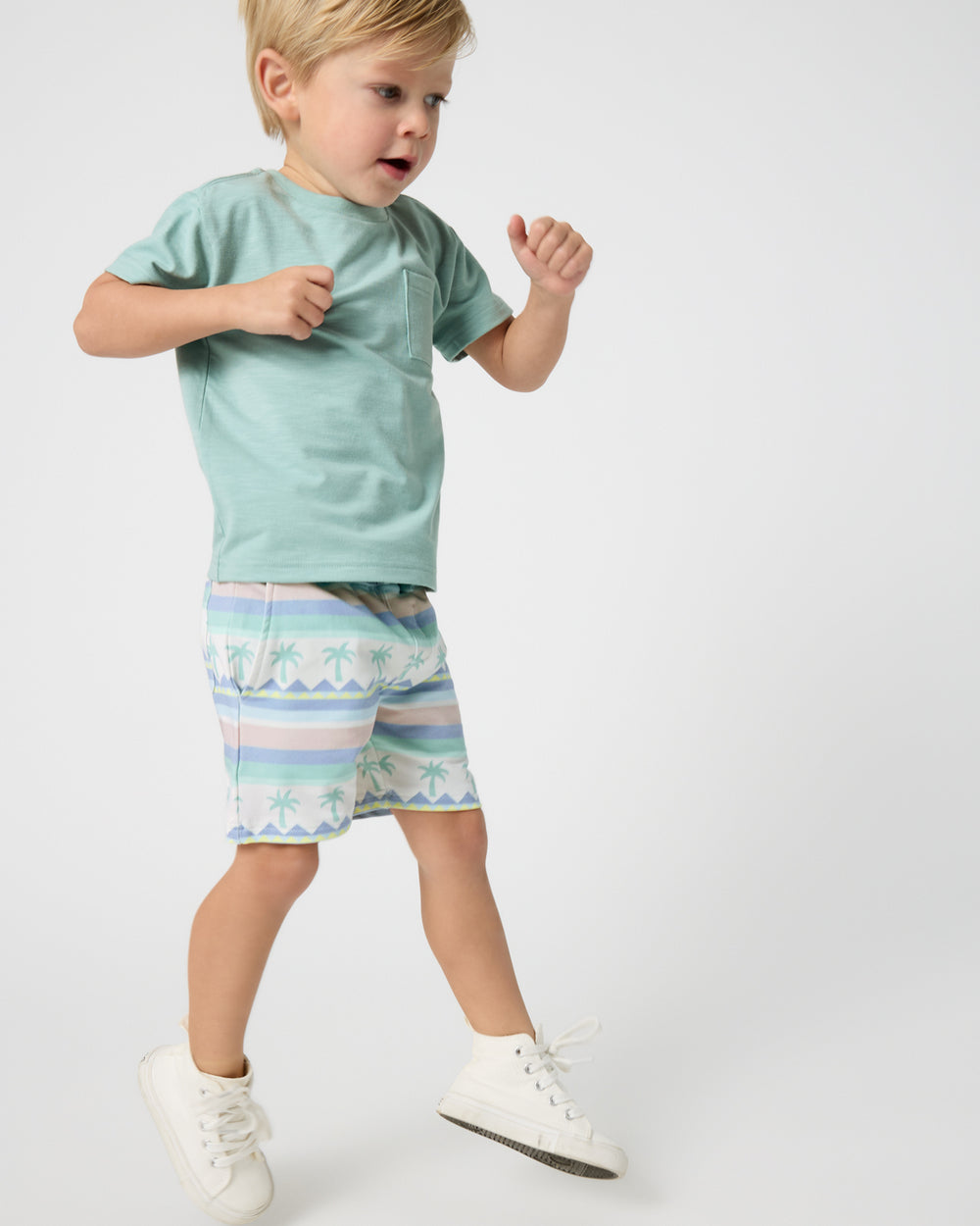 Child in motion wearing the Aqua Surf Relaxed Pocket Tee and Swell Stripes Drawstring Shorts