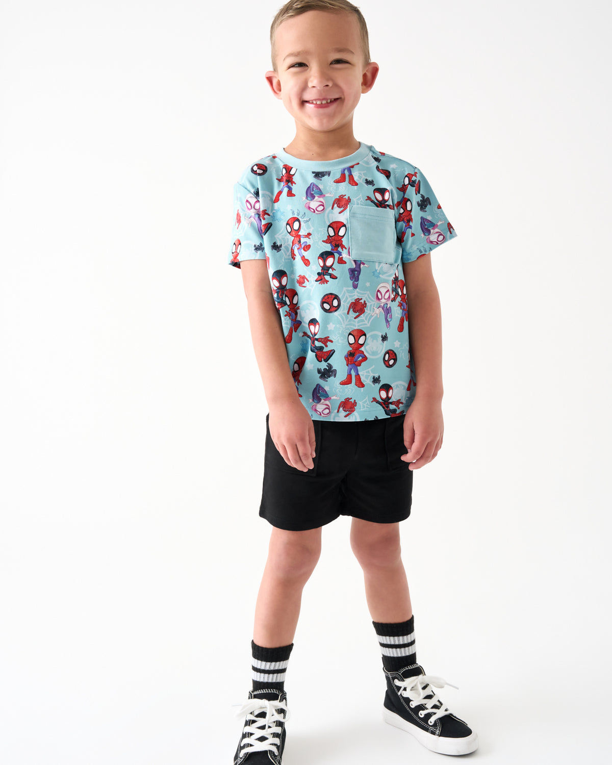 Standing boy wearing the Spidey & Friends Tiny Webs Relaxed Pocket Tee with black shorts