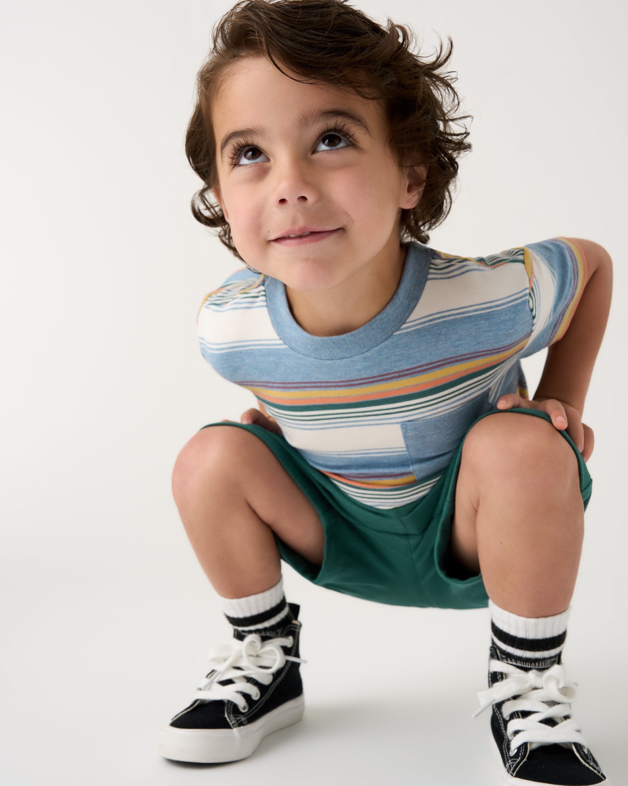 Crouching child wearing the Explorer Stripes Relaxed Pocket Tee