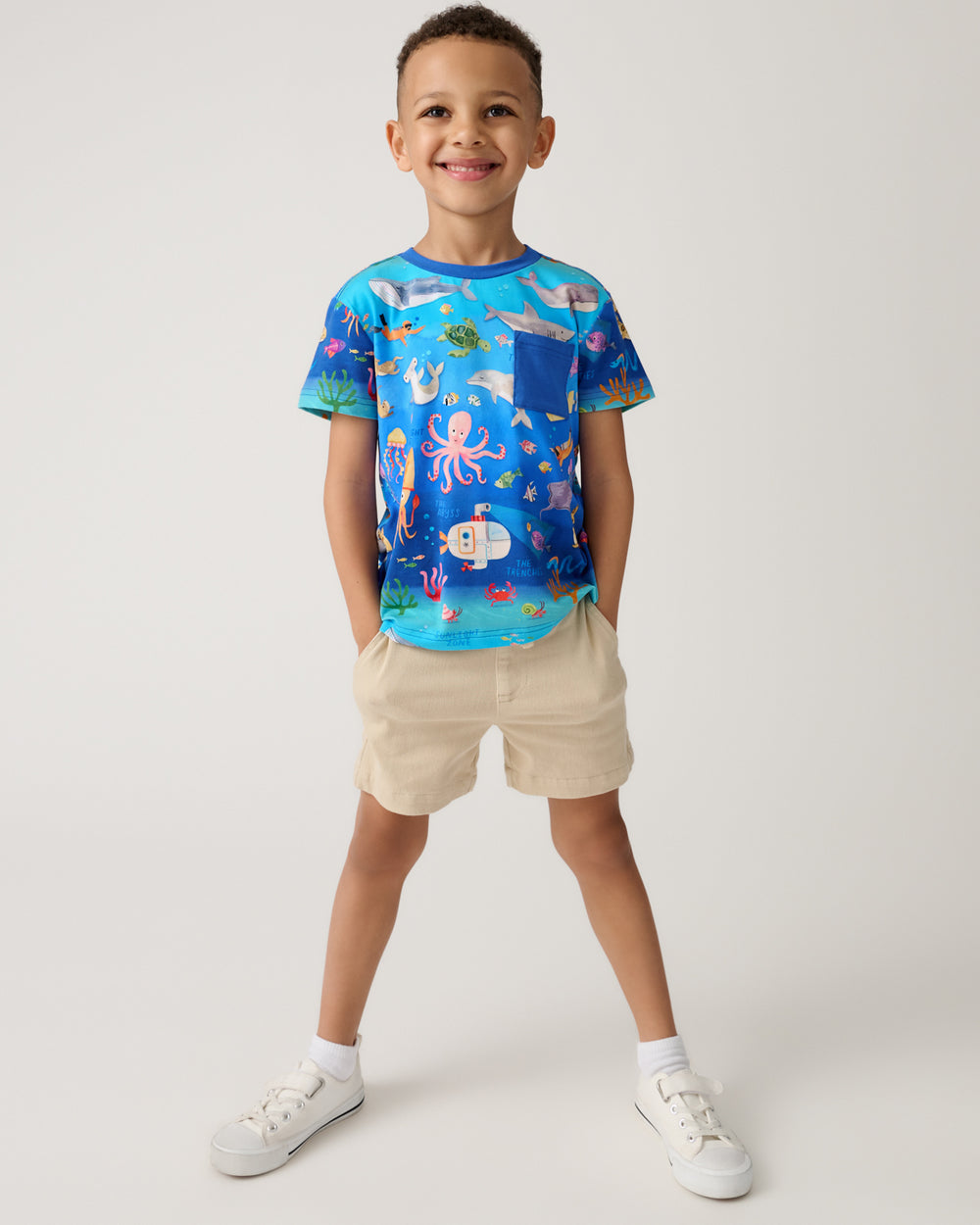 Boy wearing the Underwater Discovery Relaxed Pocket Tee with khaki shorts
