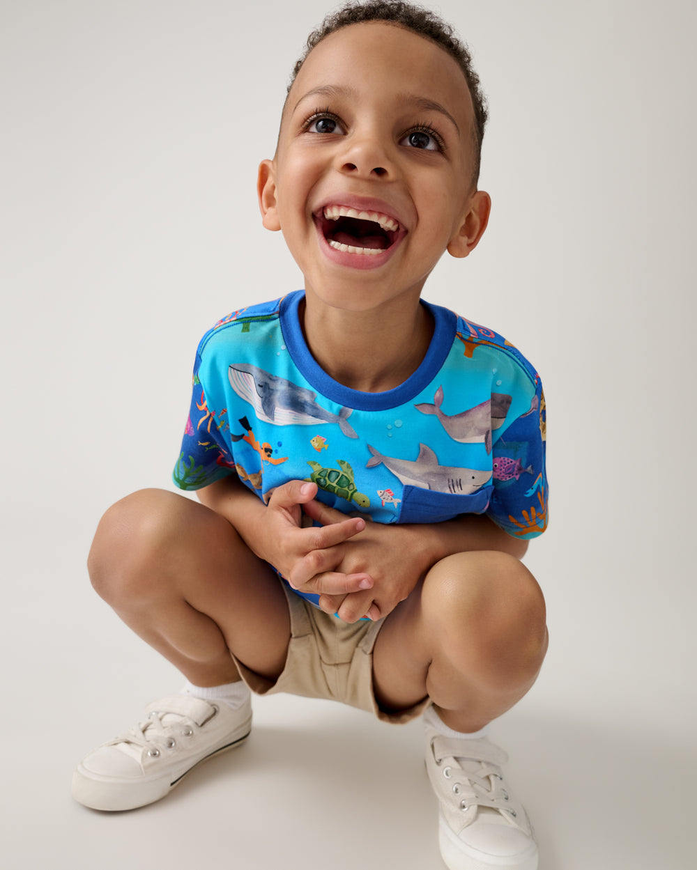 Crouching boy wearing the Underwater Discovery Relaxed Pocket Tee