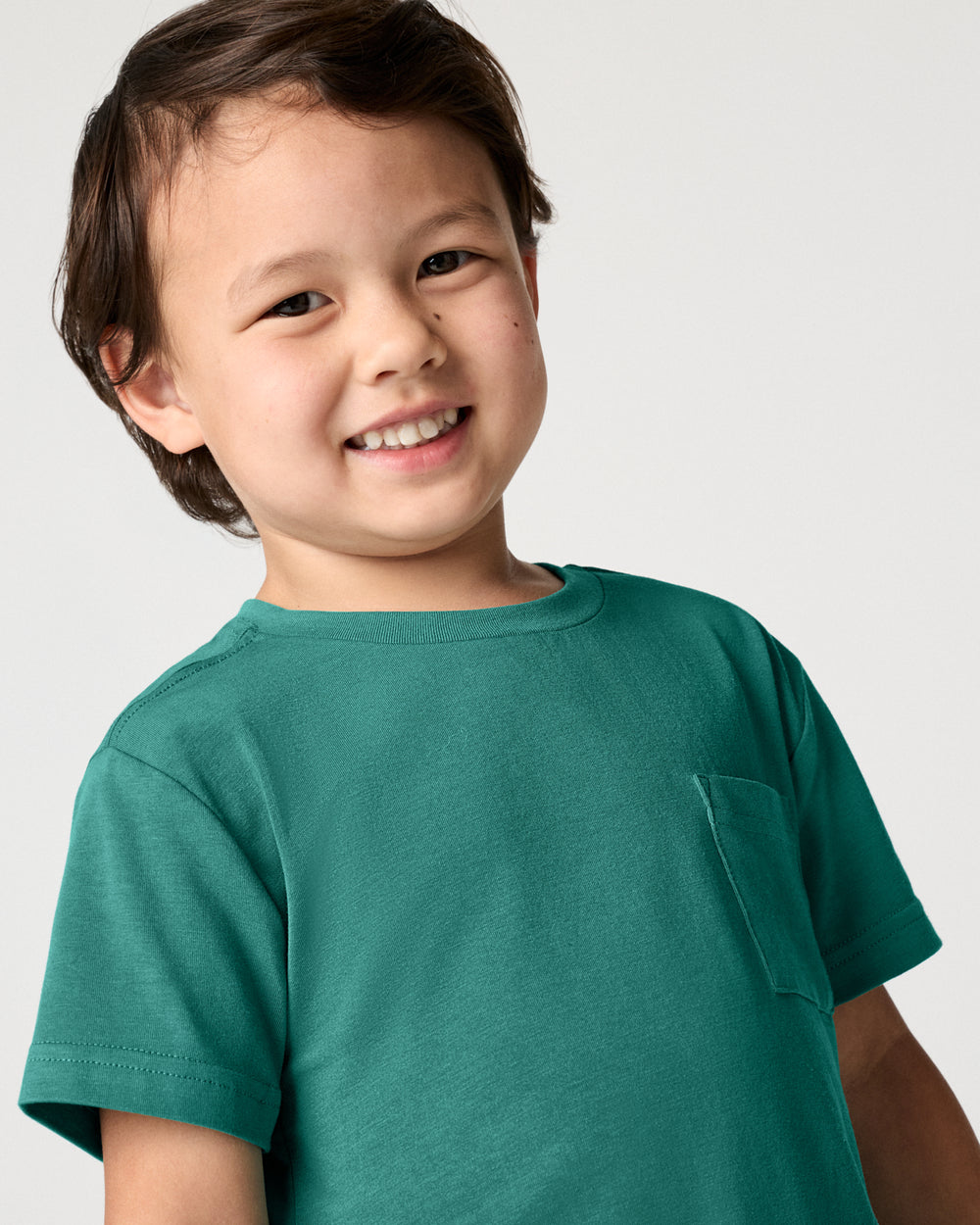 Close up of boy wearing the Emerald Isle Relaxed Pocket Tee